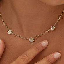 Carica l'immagine nel visualizzatore di Gallery, Collana con tre fiori e cristalli applicati su di essi in acciaio dorato di sagapo indossata e vista da vicino