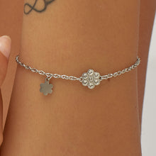 Carica l'immagine nel visualizzatore di Gallery, Bracciale con simbolo fiore in acciaio lucido e cristalli bianchi di sagapo gioielli indossato e visto da vicino