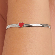 Carica l'immagine nel visualizzatore di Gallery, Bracciale a maglia Snake piatta con cuore smaltato rosso In acciaio color argento indossato e visto da vicino