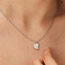 Carica l'immagine nel visualizzatore di Gallery, collana con pendente a forma di angelo con stella e pietra bianca in metallo bianco indossata e vista da vicino