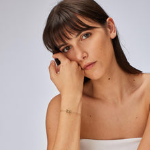 Carica l'immagine nel visualizzatore di Gallery, bracciale con farfalla traforata e pietra bianca in metallo dorato indossato