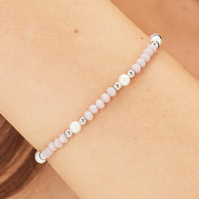 Carica l'immagine nel visualizzatore di Gallery, Bracciale con sfere in acciaio sfere di vetro rosa e perle bianche indossato e visto da vicino