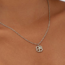 Carica l'immagine nel visualizzatore di Gallery, Collana con pendente a forma di quadrifoglio in Acciaio con cristallo bianco indossata e vista da vicino