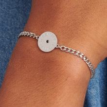 Carica l'immagine nel visualizzatore di Gallery, bracciale da uomo in acciaio con catenina a maglia grumetta sottile e targa tonda centrale con cristallo colore Jet e scritte dedicate ai fratelli. indossato e visto da vicino
