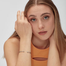 Carica l'immagine nel visualizzatore di Gallery, bracciale rigido in acciaio lucido con cristalli bianchi di sagapò click indossato
