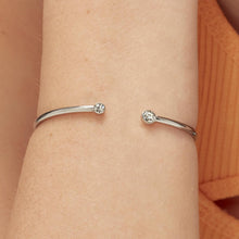 Carica l'immagine nel visualizzatore di Gallery, bracciale rigido in acciaio lucido con cristalli bianchi di sagapò click indossato e visto da vicino
