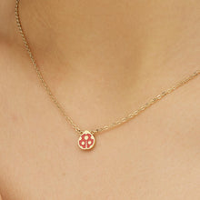 Carica l'immagine nel visualizzatore di Gallery, collana in acciaio dorato con coccinella smaltata di rosso di s'agapò Click indossata e vista da vicino
