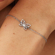 Carica l'immagine nel visualizzatore di Gallery, bracciale con farfalla traforata e pietra bianca in metallo bianco indossato e visto da vicino
