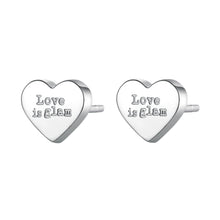 Carica l'immagine nel visualizzatore di Gallery, orecchini a forma di cuore con scritta 'love is glam' in acciaio color argento di sagapo click
