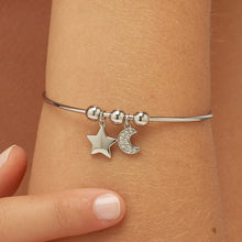 Carica l'immagine nel visualizzatore di Gallery, bracciale rigido in acciaio con sfere e stella e luna pendenti con cristalli applicati sulla luna. indossato e visto da icino
