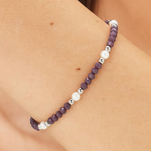 Carica l'immagine nel visualizzatore di Gallery, Bracciale con sfere in acciaio sfere di vetro viola e perle bianche indossato e visto da vicino
