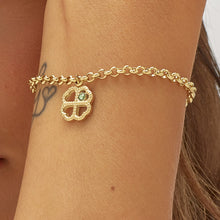 Carica l'immagine nel visualizzatore di Gallery, bracciale con pendente a forma di quadrifoglio in Acciaio dorato con cristallo verde, indossato e visto da vicino
